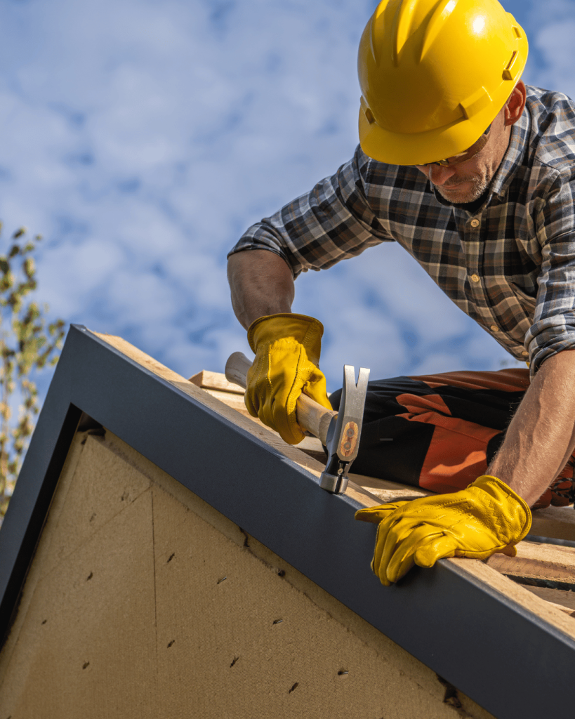 A contractor working on a damaged roof at the edge.